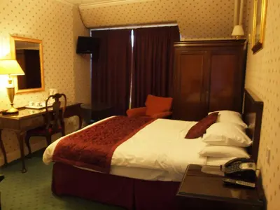 a hotel room with a bed and a desk with a telephone at Argyll Arms Hotel in Campbeltown