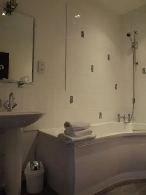 a bathroom with a tub and a sink and a mirror at Argyll Arms Hotel in Campbeltown
