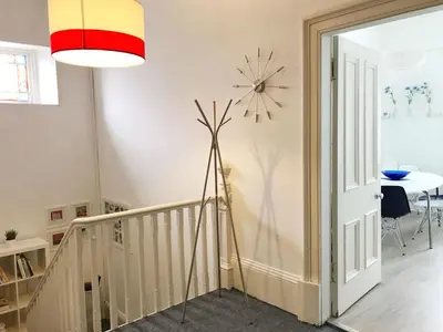 a floor lamp in a living room with a staircase at Bishopton Apartment, near Glasgow in Bishopton