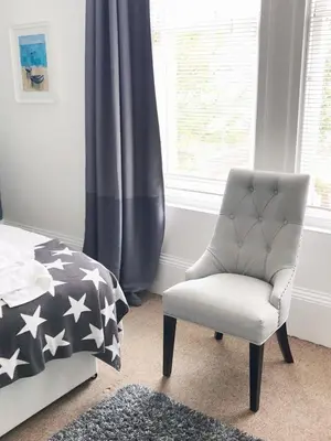 a bedroom with a chair next to a bed at Bishopton Apartment, near Glasgow in Bishopton