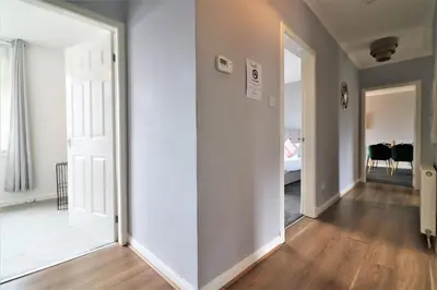 an empty hallway with a white door and a bedroom at Signature - Carfin House in Carfin