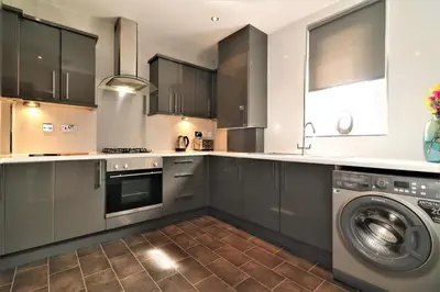 a kitchen with a washer and a washing machine at Signature - Carfin House in Carfin