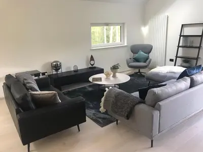 a living room with two couches and a table at Red Stag with stunning loch and waterfall view in Crianlarich