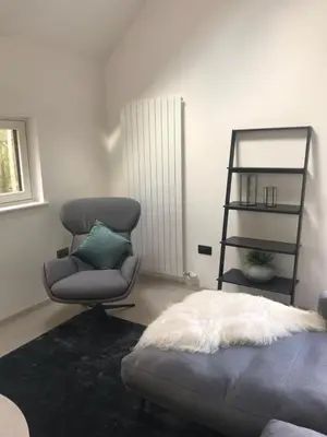 a bedroom with a chair and a bed and a ladder at Red Stag with stunning loch and waterfall view in Crianlarich