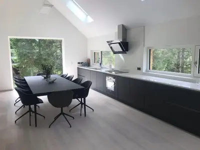 a kitchen with a black table and chairs and a counter at Red Stag with stunning loch and waterfall view in Crianlarich