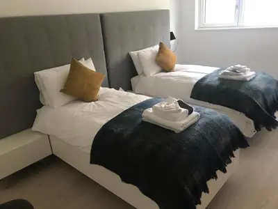 two beds in a room with towels on them at Red Stag with stunning loch and waterfall view in Crianlarich