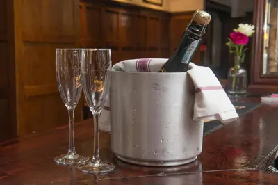 a bottle of champagne in a bucket next to two wine glasses at Babbity Bowsters in Glasgow