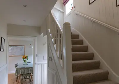 a staircase in a home with a table at Duart Cottage in Glencoe