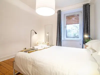 a white bedroom with a large white bed and a window at Stylish & Charming Retreat for 2- City Centre! - Pass the Keys in Edinburgh