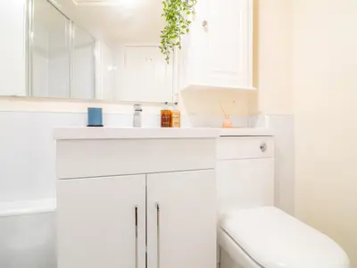 a white bathroom with a sink and a mirror at Stylish & Charming Retreat for 2- City Centre! - Pass the Keys in Edinburgh