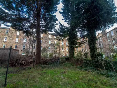 two trees in front of a large brick building at Stylish & Charming Retreat for 2- City Centre! - Pass the Keys in Edinburgh