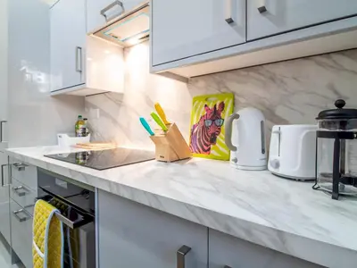 a kitchen with white cabinets and a counter top at Stylish & Charming Retreat for 2- City Centre! - Pass the Keys in Edinburgh