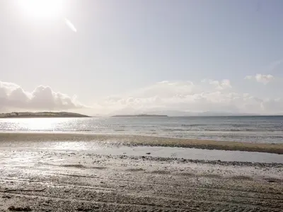 a sandy beach with the ocean in the background at Ettrick Cottage in Port Bannatyne