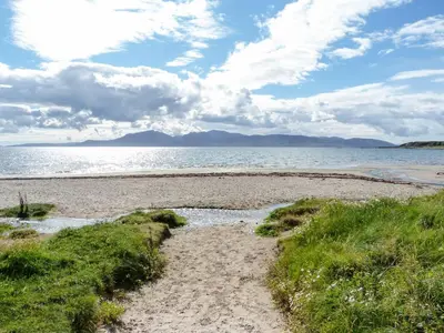 a sandy beach with the ocean in the background at Ettrick Cottage in Port Bannatyne