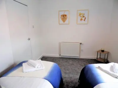 a room with two beds with towels on them at Black Cart House in Johnstone