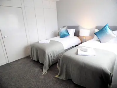 a room with two beds with blue pillows at Black Cart House in Johnstone