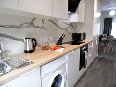 a kitchen with a washing machine and a sink at Black Cart House in Johnstone