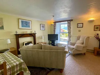 a living room with two couches and a television at TwoStones Self Catering Cottage in Arrochar