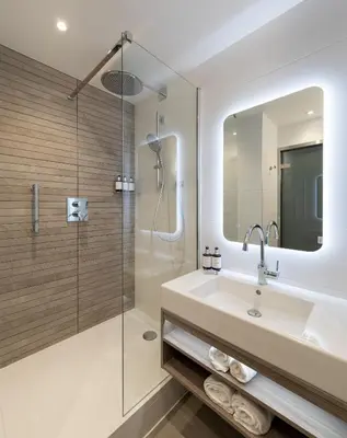 a bathroom with a sink and a shower at voco Edinburgh - Haymarket by IHG in Edinburgh