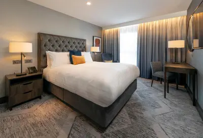 a hotel room with a large bed and a desk at voco Edinburgh - Haymarket by IHG in Edinburgh