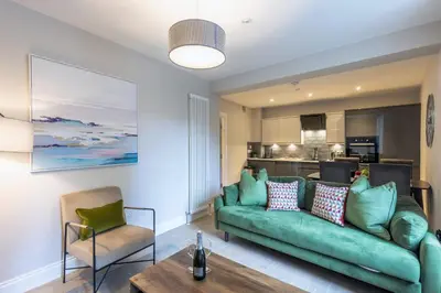 a living room with a green couch and a table at Dragon Suites - Edinburgh City Centre 2 Bed Apartment in Edinburgh