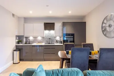 a kitchen and dining room with a table and chairs at Dragon Suites - Edinburgh City Centre 2 Bed Apartment in Edinburgh