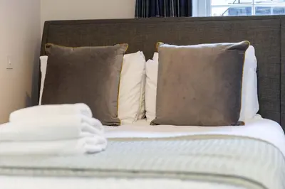 a close up of a bed with pillows at Dragon Suites - Edinburgh City Centre 2 Bed Apartment in Edinburgh