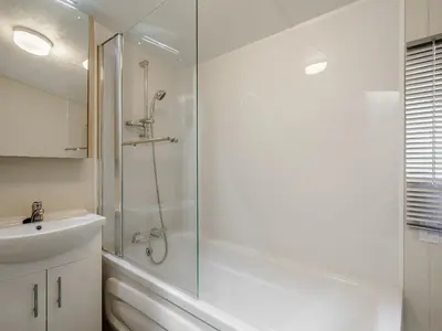 a white bathroom with a shower and a sink at The Paddocks - Uk7112 in Alloa