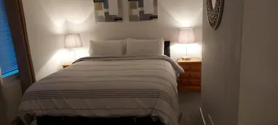 a bedroom with a large bed with two lamps on it at LAWFIELD R&R in West Kilbride