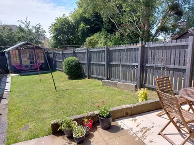 a backyard with a fence and a table and chairs at LAWFIELD R&R in West Kilbride