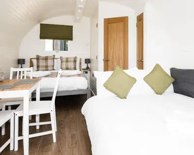 a hotel room with two beds and a table and a desk at Weedingshall Lodges in Falkirk