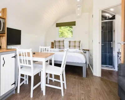 a bedroom with a bed and a table and chairs at Weedingshall Lodges in Falkirk