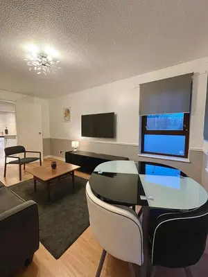 a living room with a glass table and a tv at Bijou Merchant City Apartment with Parking (Albion 1) in Glasgow