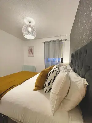 a bedroom with a large white bed with pillows at Bijou Merchant City Apartment with Parking (Albion 1) in Glasgow