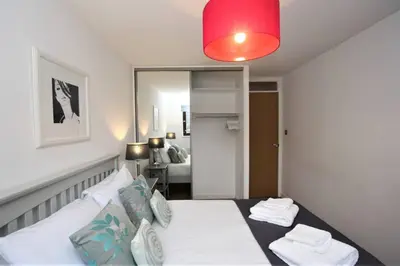a bedroom with a bed with a red light at Bijou Merchant City Apartment with Parking (Albion 1) in Glasgow