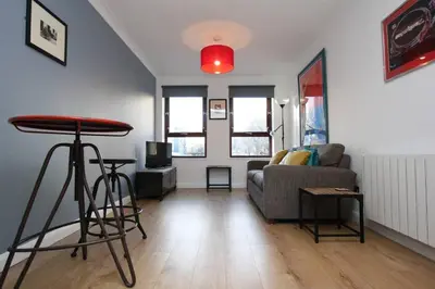 a living room with a couch and a table at Bijou Merchant City Apartment with Parking (Albion 1) in Glasgow