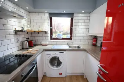 a kitchen with a washing machine and a sink at Bijou Merchant City Apartment with Parking (Albion 1) in Glasgow