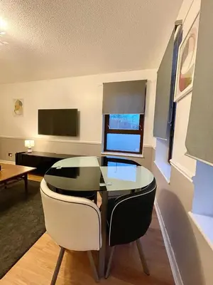 a dining room with a glass table and two chairs at Bijou Merchant City Apartment with Parking (Albion 1) in Glasgow