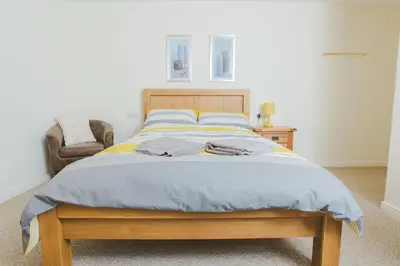 a large bed in a bedroom with a chair at Clyde View B&B in Dunoon
