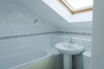 a white bathroom with a sink and a bath tub at Clyde View B&B in Dunoon