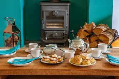 a wooden table with plates of food and bread at Seabank Lochside Farmhouse in Oban