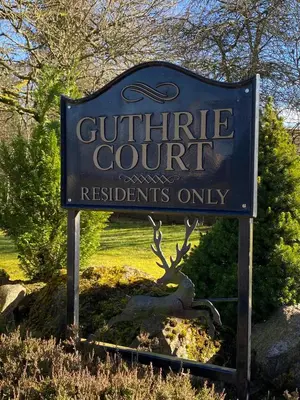 a sign for a guthrie court with a tree behind it at Gleneagles Luxury Apartment in Auchterarder
