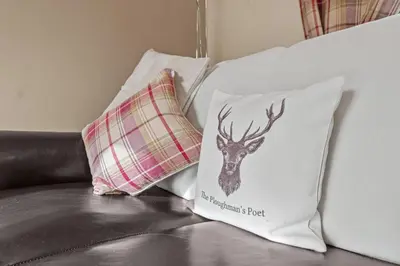 two pillows on a couch with a deer head on it at The Ploughman's Poet in Bathgate
