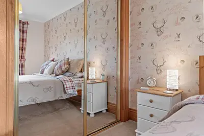 a small bedroom with a bed and a mirror at The Ploughman's Poet in Bathgate