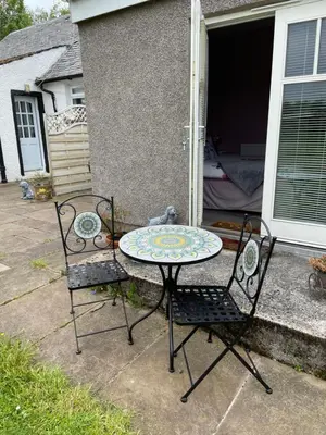 a table and two chairs sitting on a patio at Ben Lomond Cottage in Gartocharn