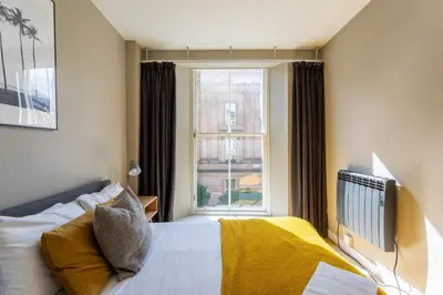 a bedroom with a bed and a window at Merchant City Apartment in Glasgow