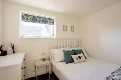 a white bedroom with a bed and a window at South Barlogan Farm in Bridge of Weir