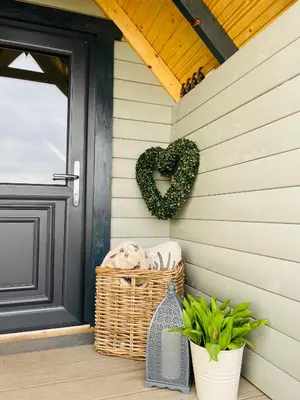 a wicker basket on a porch with a heart wreath at South Barlogan Farm in Bridge of Weir