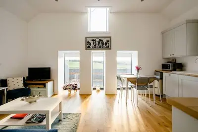 a kitchen and living room with a table and chairs at South Barlogan Farm in Bridge of Weir