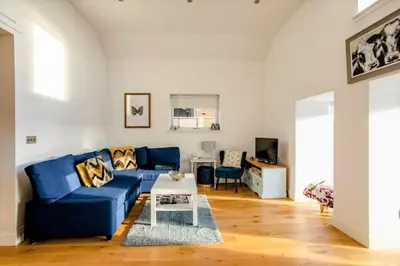 a living room with a blue couch and a table at South Barlogan Farm in Bridge of Weir